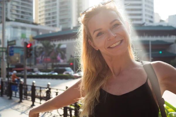 Mulher loira atraente sorrindo na cidade — Fotografia de Stock