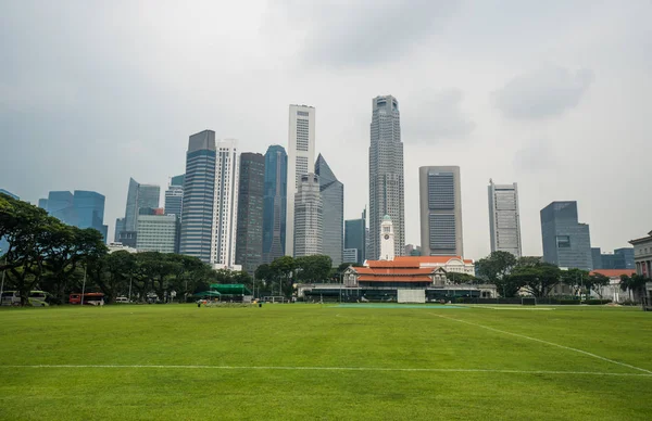 Singapur paisaje urbano con campo de fútbol y edificios comerciales altos —  Fotos de Stock