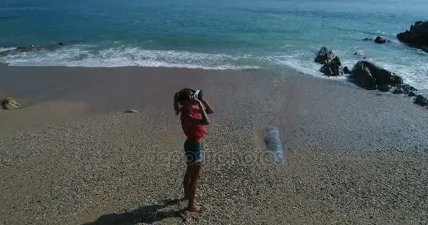 Женщина использует очки виртуальной реальности на пляже — стоковое видео
