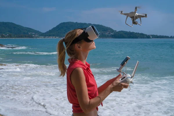 Femme avec caméra drone et lunettes de réalité virtuelle prenant des photos et des vidéos sur la plage — Photo