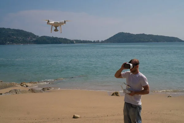 Homme avec caméra drone et lunettes de réalité virtuelle prenant des photos et des vidéos sur la plage — Photo