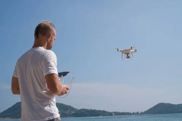 Homme avec appareil photo drone prenant des photos sur la plage — Photo