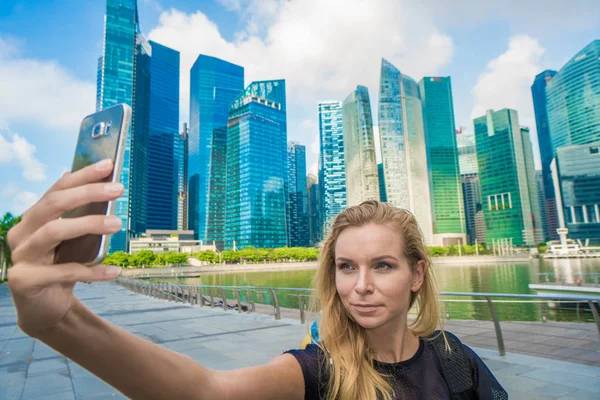 Turista mujer tomando foto selfie teléfono móvil en Singapur paisaje urbano —  Fotos de Stock