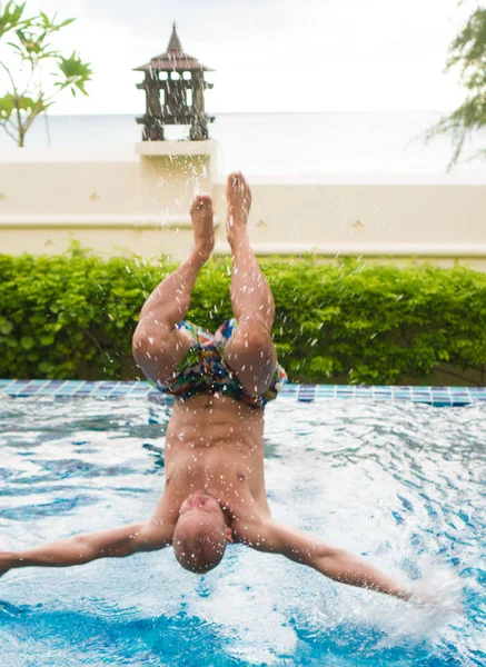 Homme sautant dans la piscine extérieure — Photo