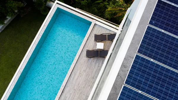 Вид с воздуха на бассейн и солнечные панели — стоковое фото