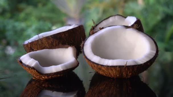 Kokosnoten op de zwarte glazen tafel geïsoleerd over wazig palm bomen achtergrond — Stockvideo
