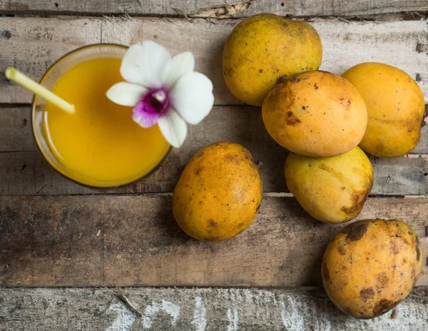 Mango smoothie en vruchten op de houten tafel — Stockfoto