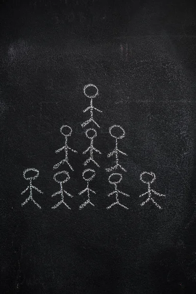 Human team pyramid on black chalkboard — Stock Photo, Image