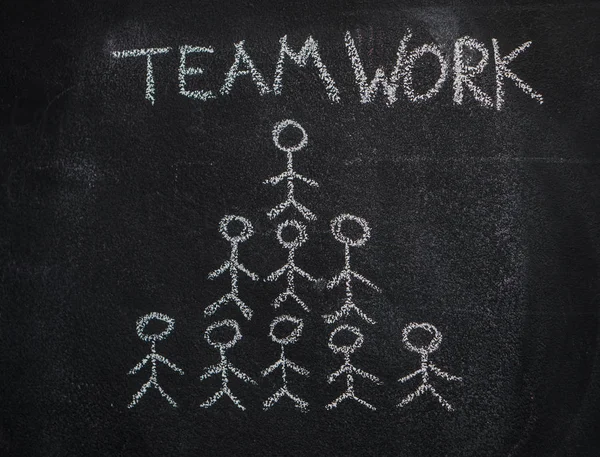 Human team pyramid and teamwork word on black chalkboard — Stock Photo, Image