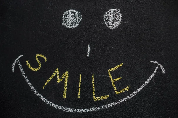 Cara de desenho animado feliz com palavra sorriso no quadro negro — Fotografia de Stock