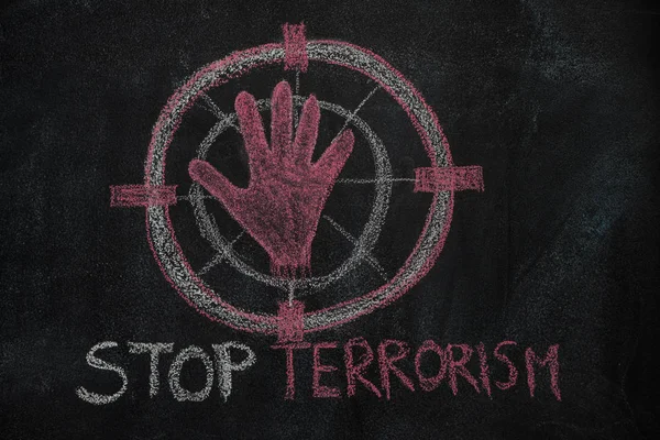 Forma da mão vermelha e parar texto terrorismo no alvo sinal no quadro preto — Fotografia de Stock