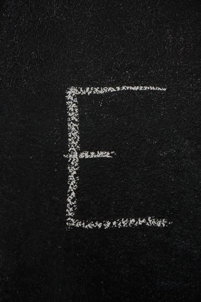 Літера E на чорній дошці — стокове фото