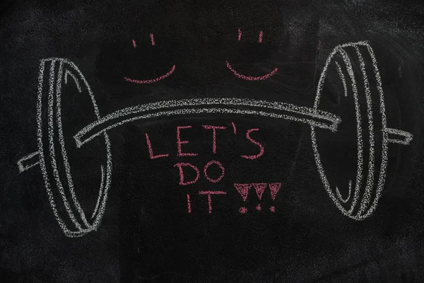 Barbell and Let 's do it text on black chalkboard — стоковое фото