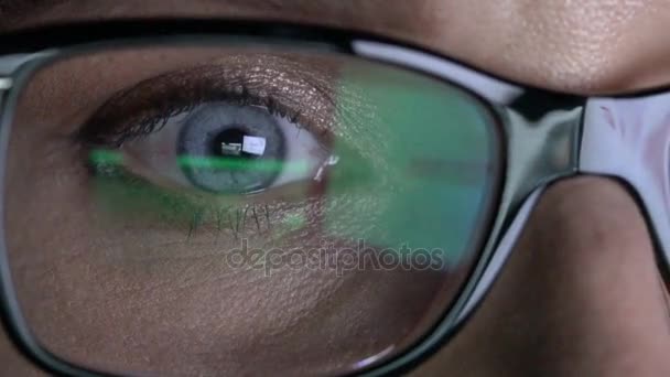 Closeup woman's eye in glasses works on laptop at night — Stock Video