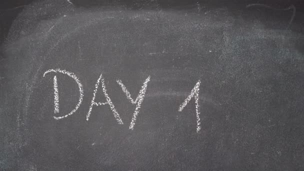 Hand writing "DAY 1, 2 & 3" on black chalkboard — Stock Video