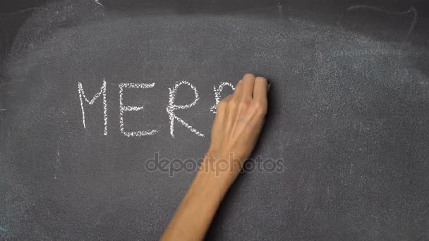 Χέρι που γράφει «Καλά Χριστούγεννα» στον μαύρο πίνακα κιμωλίας — Αρχείο Βίντεο