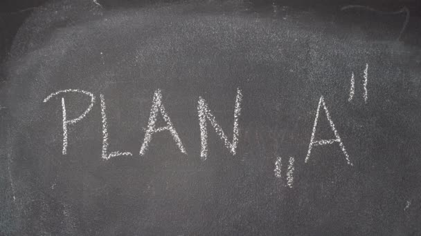 Hand schrijven "Plan A, B" en "Wat is uw Plan?" vraag over zwarte schoolbord — Stockvideo