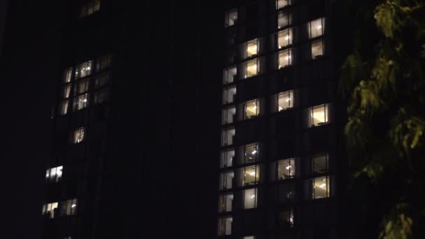 Вечером снаружи здания с внутренним освещением — стоковое видео