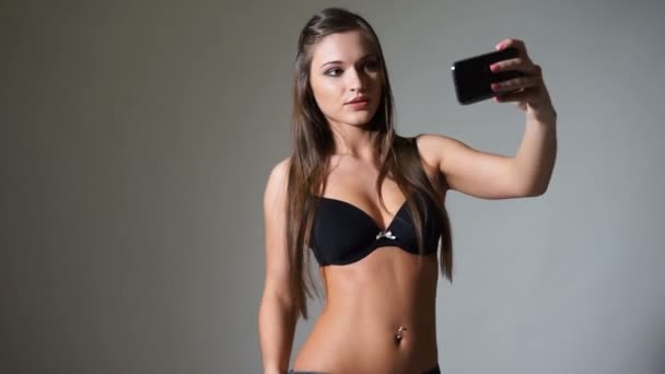 Mooi meisje in beha en jeans doen selfie foto — Stockvideo