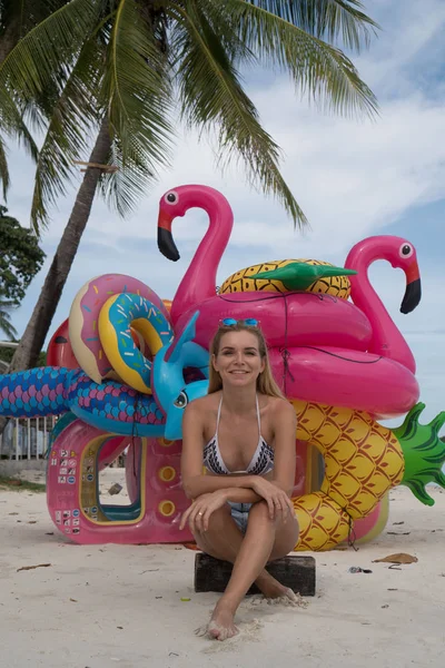 Femme heureuse avec des jouets gonflables sur la plage — Photo