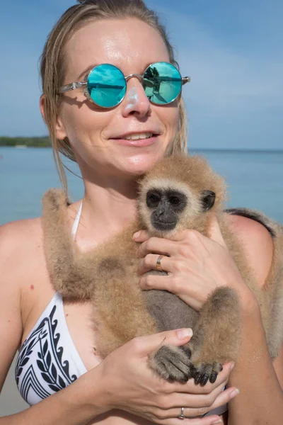 Mulher com macaco na praia — Fotografia de Stock
