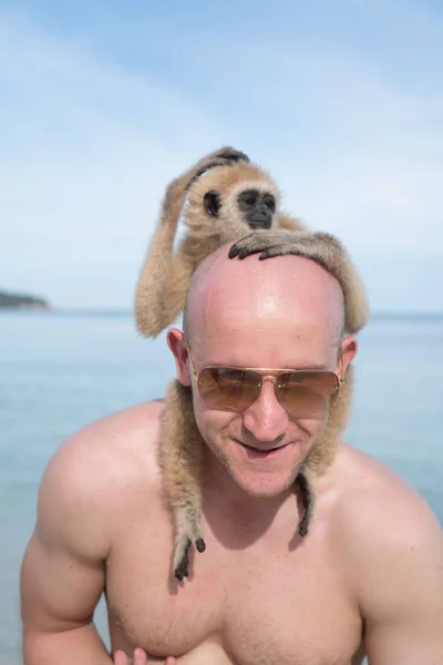 Homme avec singe sur la plage — Photo