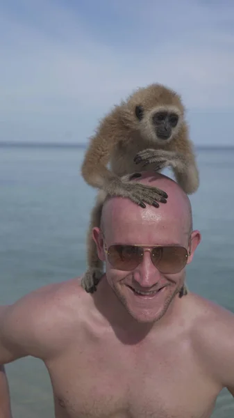 Man with monkey on the beach — Stock Photo, Image
