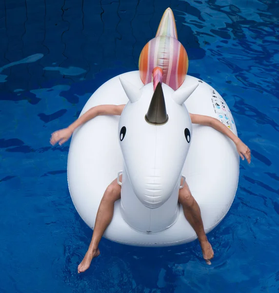 Woman with big inflatable unicorn in the pool — Stock Photo, Image