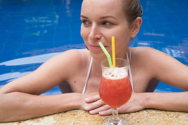 Vrouw met cocktail in het zwembad — Stockfoto