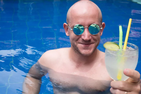 Man met cocktail in het zwembad — Stockfoto
