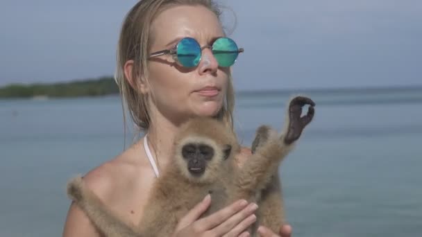 Kvinna med apa på stranden — Stockvideo