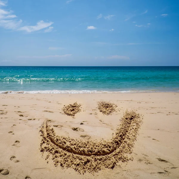 Lächeln Gesicht zeichnen am Strand über dem Meer — Stockfoto