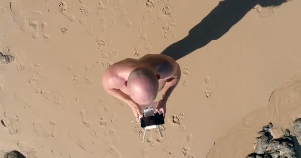 Чоловік працює безпілотник на пляжі — стокове відео
