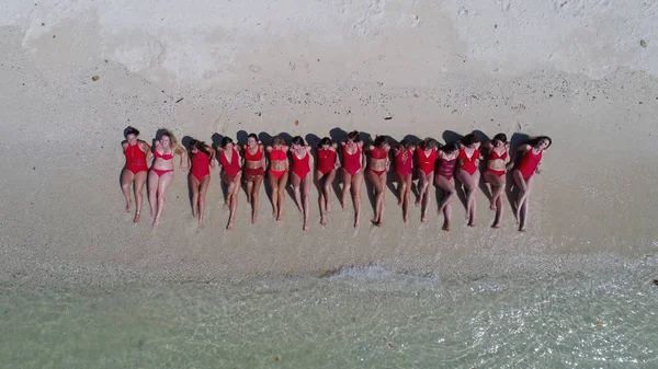 熱帯の砂浜のビーチで日光浴する赤の水着で幸せな女性の空中ドローン平面図 — ストック写真