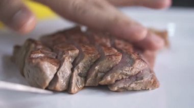 Closeup şefin eller temiz tabağa dilimlenmiş dana biftek koyarak. Yemek hazırlama kavramı - ağır çekim video