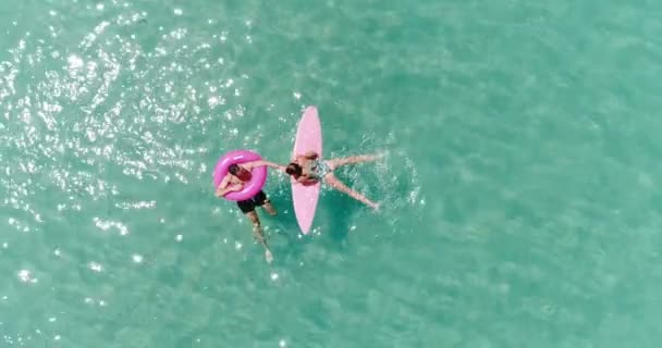 驚くほど澄んだ海水 スローモーションのビデオで彼らの休日を楽しんでいるカップルの航空写真 — ストック動画