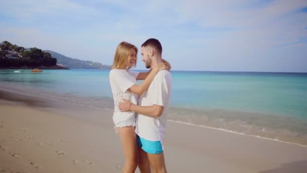美しい幸せなカップル 海と空の背景に熱帯の砂浜でおんぶをして楽しんで — ストック動画