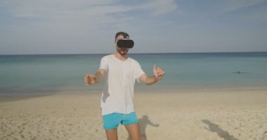 Genç adam onun toplantı sanal gerçeklik gözlükle tropik sahilde güzel kadın güzel deniz üzerinde tarih ve arka plan gökyüzü