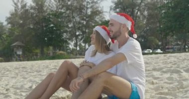 Kış tatilinde - ağır çekimde video tropikal seyahat hedef üzerinde seyahat tatil günlerinde aşık yaz güneşte Noel Baba şapkası giyen Noel güzel plaj Çift