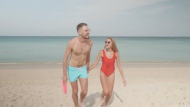 Mutlu çift frizbi uçan disk ile sahilde güneşli yaz gün boyunca oynamak.