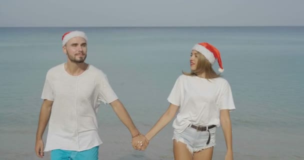 スロー モーション ビデオ冬のホリデー中に熱帯旅行目的地の旅行の祝日に恋夏太陽の下でサンタの帽子をかぶってクリスマス美しいビーチ カップル — ストック動画