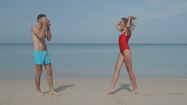 年轻快乐的情侣泳装在他们的海滩上拍照的乐趣热带假日 视频慢动作 — 图库视频影像