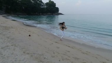 -Ağır çekimde video kum plajındaki sabah koşu güzel genç kız görünümünü hava uçak