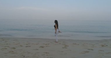 -Ağır çekimde video kum plajındaki sabah egzersiz güzel genç kızın havadan görünümü