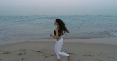-Ağır çekimde video kum plajındaki sabah koşu güzel genç kız görünümünü hava uçak