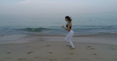 -Ağır çekimde video kum plajındaki sabah koşu güzel genç kız görünümünü hava uçak