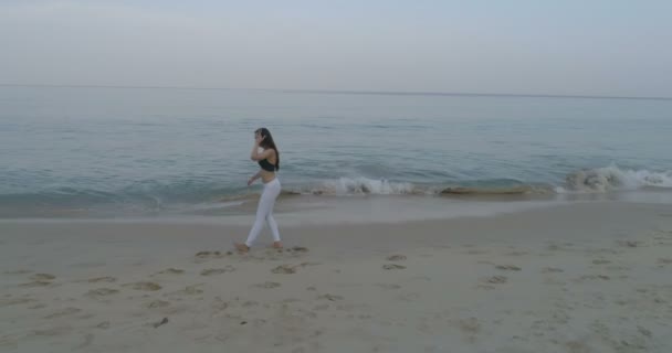 美丽的年轻女孩的空中观运动在早晨沙滩上 视频慢动作 — 图库视频影像