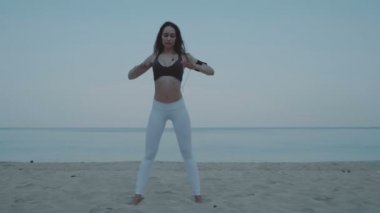 Güzel kız egzersiz kum plajındaki / güzel genç kız - ağır çekimde video kum plajındaki sabah egzersiz