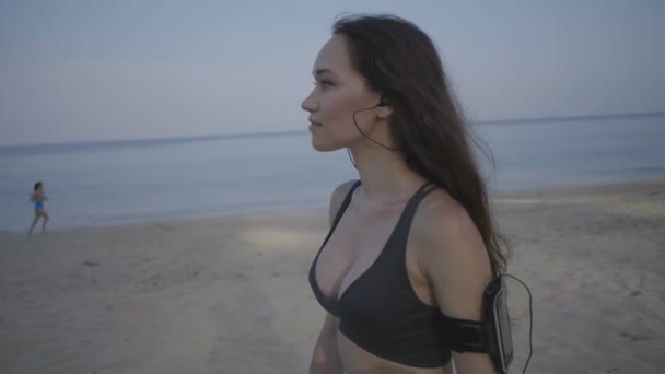 美丽的女孩在沙滩上慢跑 美丽的女孩走前清晨在沙滩上慢跑 视频慢动作 — 图库视频影像
