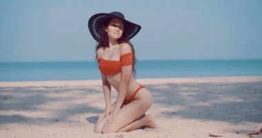 Güzel kız tropik sahilde / güzel kız bikini ve şapka rahatlatıcı yaz tatili sırasında güneşin tropikal plaj - ağır çekim video